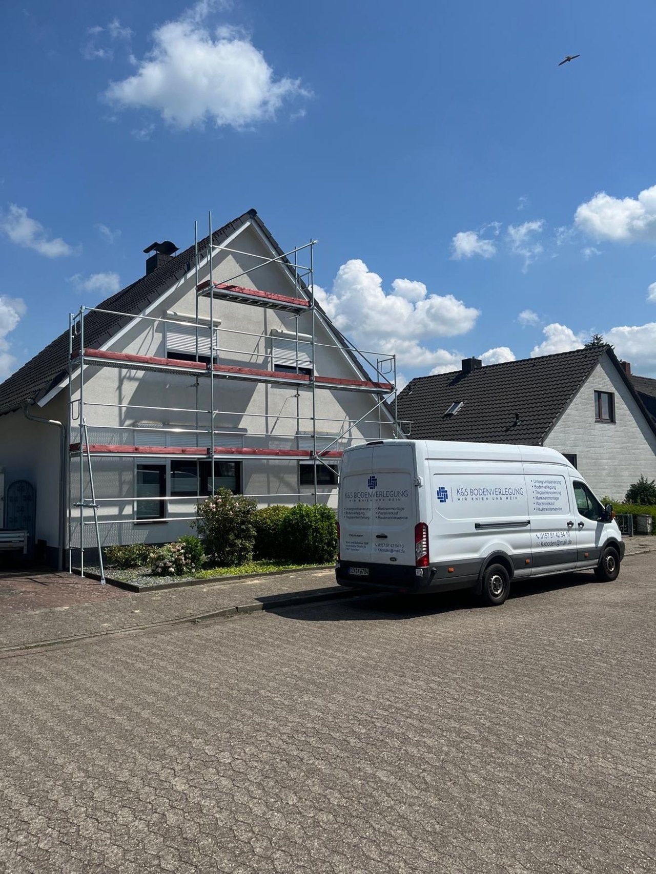 Beschrifteter Firmenwagen von K&S Bodenverlegung vor einem Wohnhaus im Einsatzgebiet