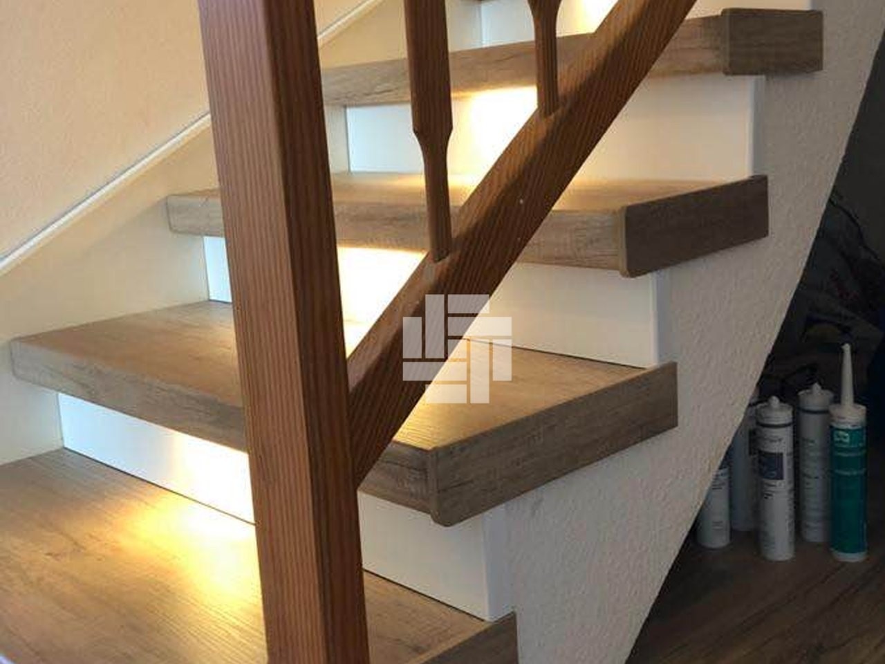 Renovierte Treppe mit Stufen in Holzoptik und indirekter LED-Beleuchtung